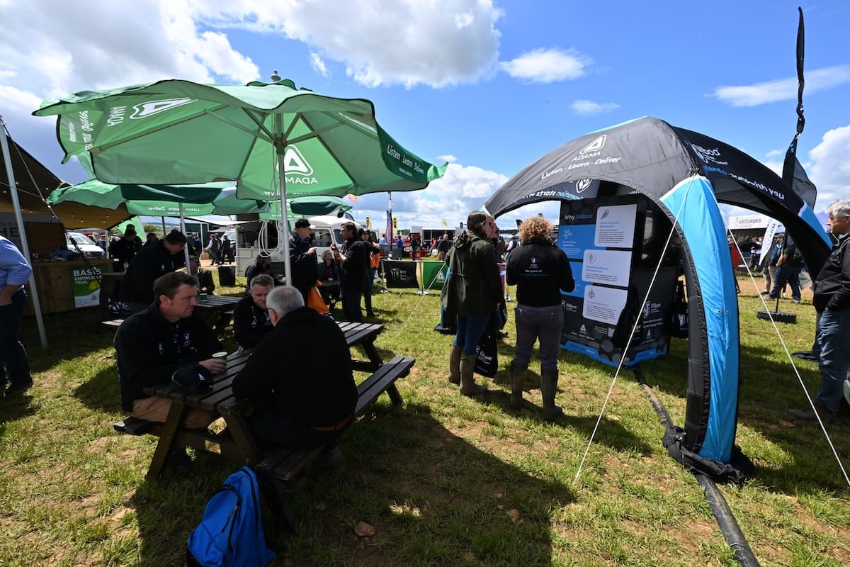 adama-cereals-2026-parasols-inflatable-gazebo ADAMA branded green parasols and inflatable gazebo stand at Cereals 2026 with visitors.