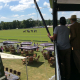 Guests watching a polo match from a hospitality structure balcony overlooking Jaeger-LeCoultre branded pitch-side seating