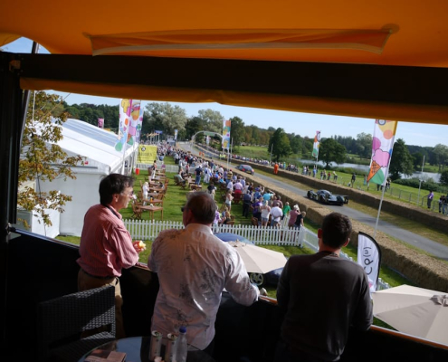 View from a HEXIS Sky Lounge upper deck overlooking a live motorsport event and hospitality area