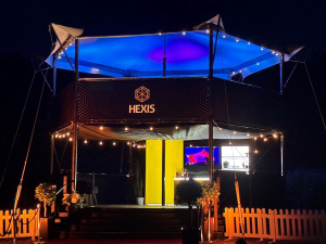 hexis-sky-lounge-structure-blue-canopy-lighting-night HEXIS elevated hospitality structure at night lit with blue canopy lighting and string lights.