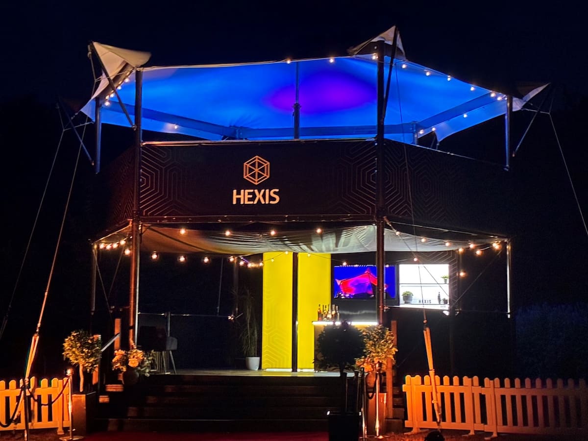 hexis-sky-lounge-structure-blue-canopy-lighting-night HEXIS elevated hospitality structure at night lit with blue canopy lighting and string lights.