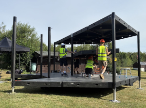 hexis-structure-build-team-installation Access Displays crew building the HEXIS structure frame on site in high-vis workwear.