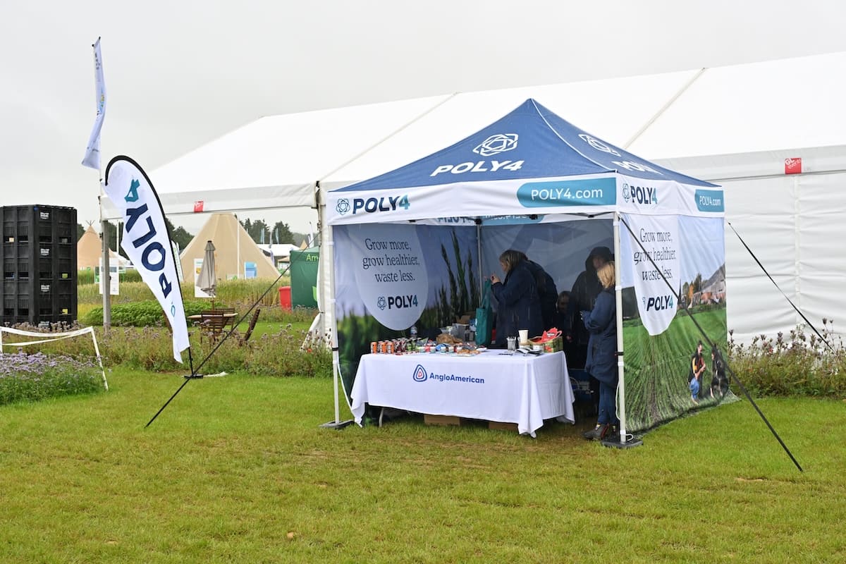 poly4-anglo-american-gazebo-cereals-2026 Poly4 branded gazebo stand with AngloAmerican table at Cereals 2026 in the rain.