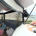 Panoramic view of a HEXIS beach lounge structure with striped seating and bunting, overlooking a seafront and pier