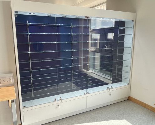 large-wall-mounted-glass-showcase-multiple-shelves Large wall-mounted glass showcase with multiple adjustable glass shelves, spotlights and lockable base cupboards