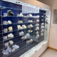 Bespoke wall-mounted glass display cabinet with navy blue backdrop, illuminated glass shelves and white 3D-printed heart models, beside an Axial3D donor plaque at Southampton hospital